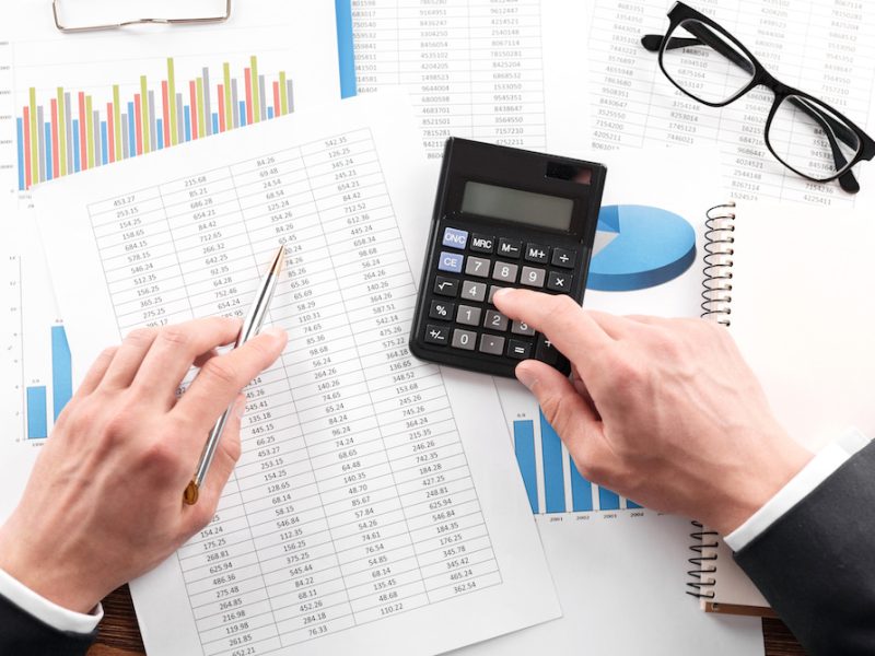 Businessman working with using a calculator to calculate the numbers. Finance accounting concept